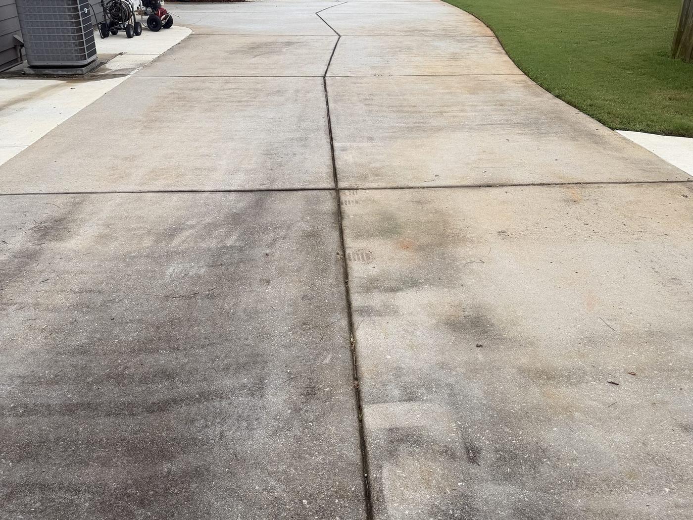 Concrete driveway in Loganville, GA before and after pressure washing, before